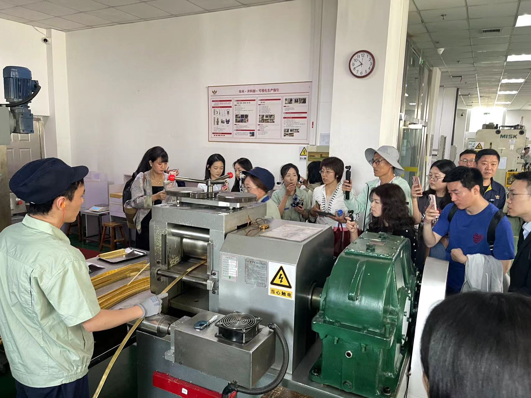 <p>招金精炼讲解员为媒体参访团介绍开料、压片等工艺流程</p>